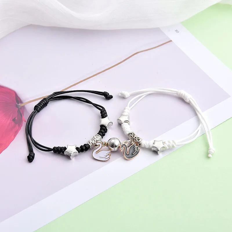 Alloy couple bracelets with magnet closure showing various design options including crown, clover, and text patterns