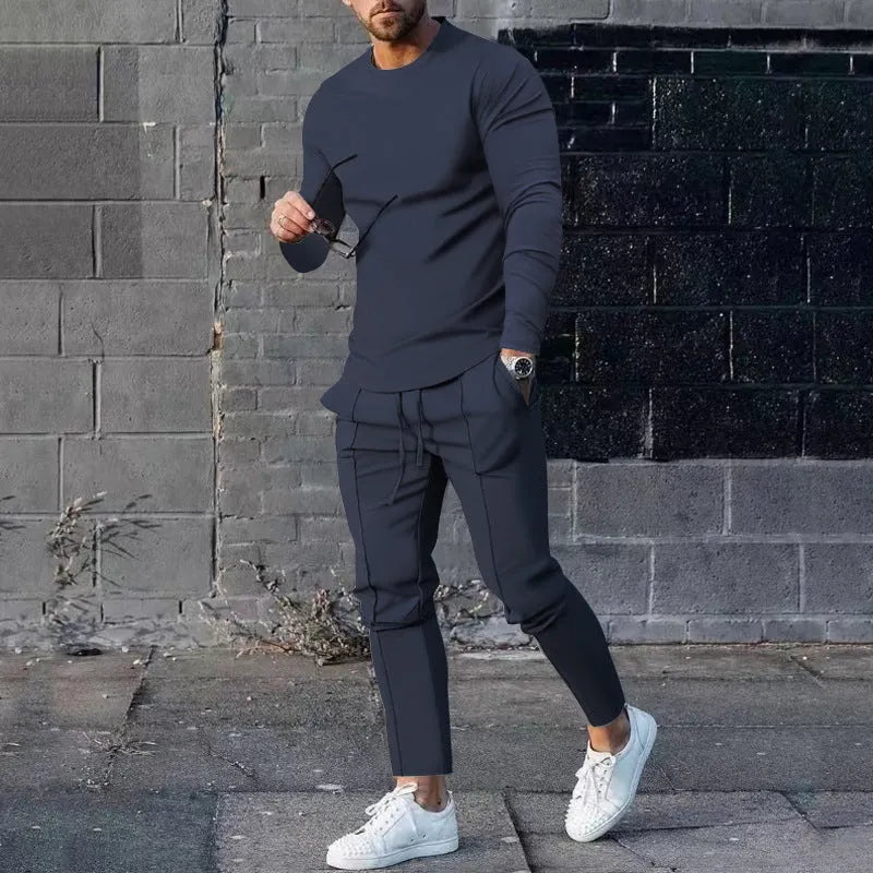Men's light grey polyester two-piece suit with long sleeve round neck T-shirt and matching trousers laid flat.