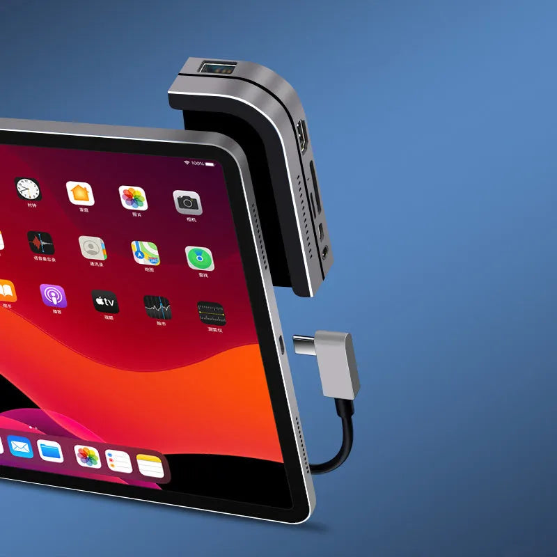 Silver aluminium grey 6-in-1 USB-C docking station for iPad Pro, shown next to a tablet.