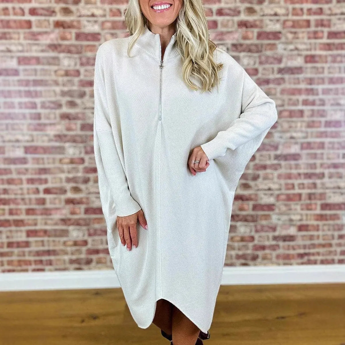 Women's loose-fit knitted dress in navy blue with a front zip closure and raglan sleeves.
