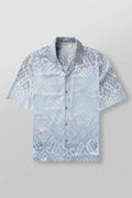Man wearing a loose-fit, short sleeve floral print top in a neutral colour.