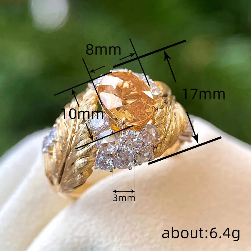 Gold-coloured embossed feather ring with geometric pattern and yellow zircon stone