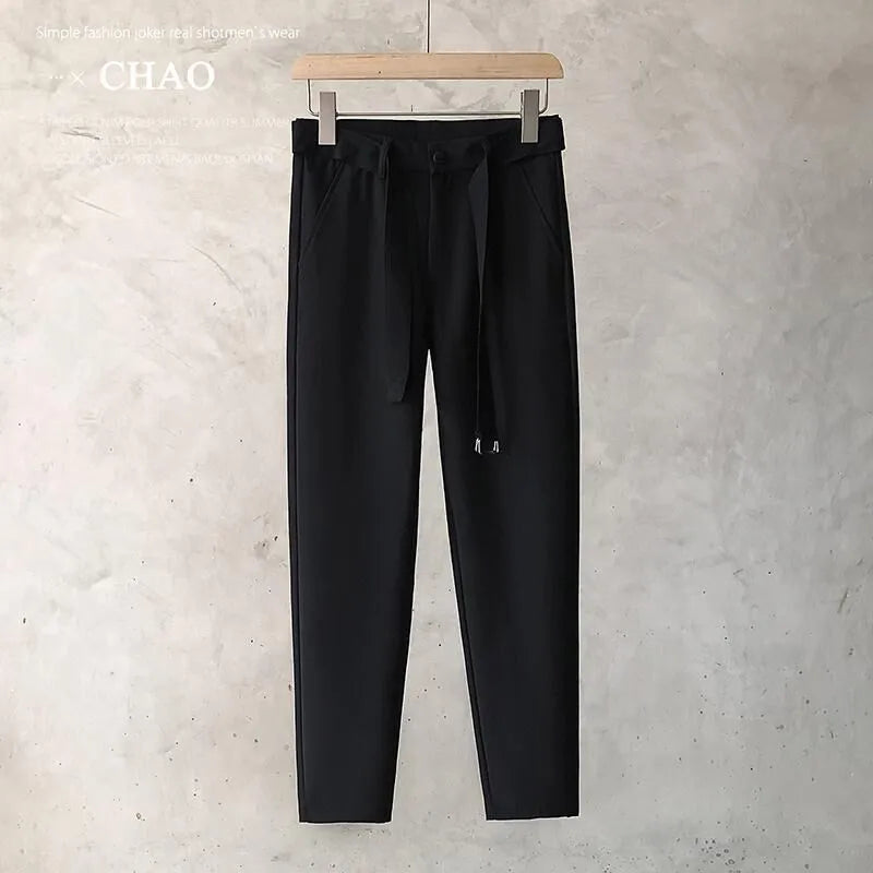 Boy wearing slim straight wool trousers in a neutral colour, showcasing the tapered fit and straight leg opening.