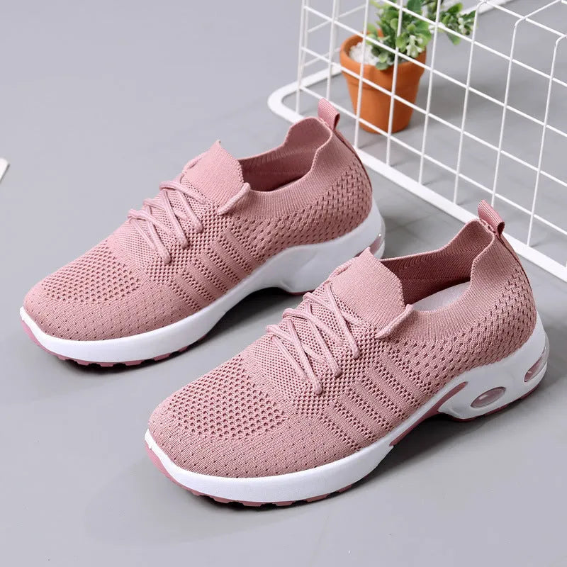 Women's black mesh casual sneakers with round toe and white non-slip sole on a grey background.
