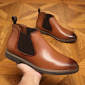 Black and brown formal pointed-toe leather boots with square heel and rubber sole.