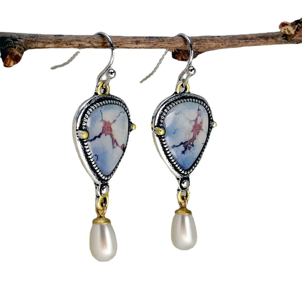 Retro blue geometric drop earrings with synthetic opal and pearl details on a two-tone electroplated metal setting.