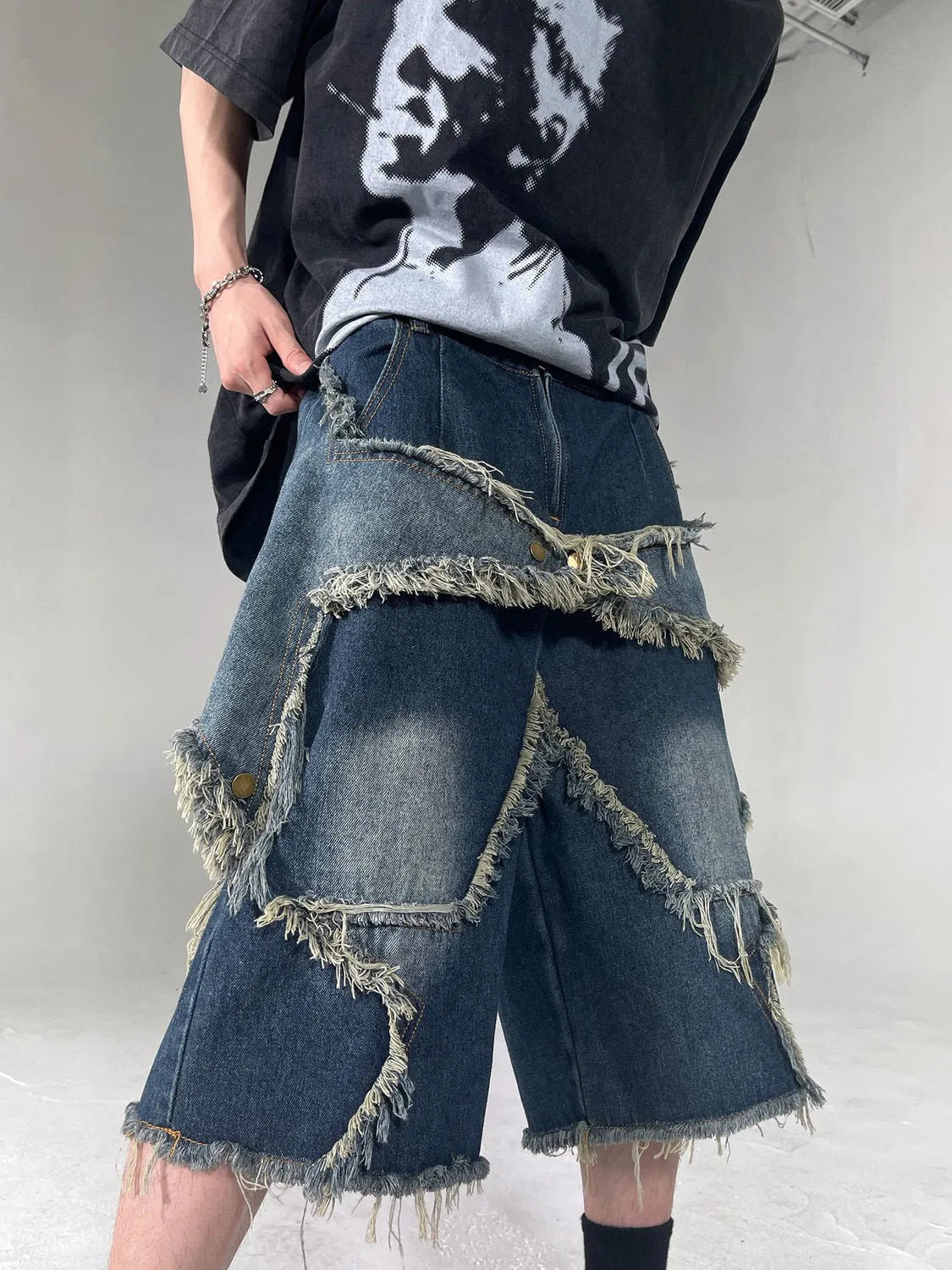 Blue denim shorts with five-pointed star detailing and frayed edges in loose fit style