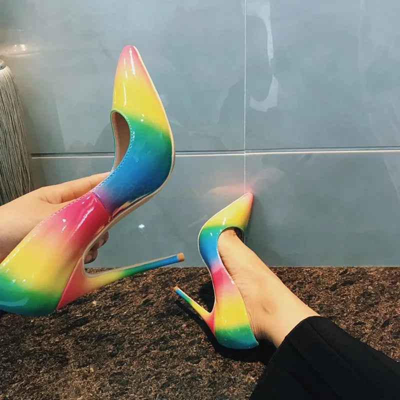 Rainbow coloured patent leather women's high heel shoe with pointed toe and thin high heel.