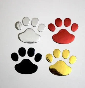Pair of hand-shaped brush dog footprint PVC car stickers in red, shown against a car bumper.