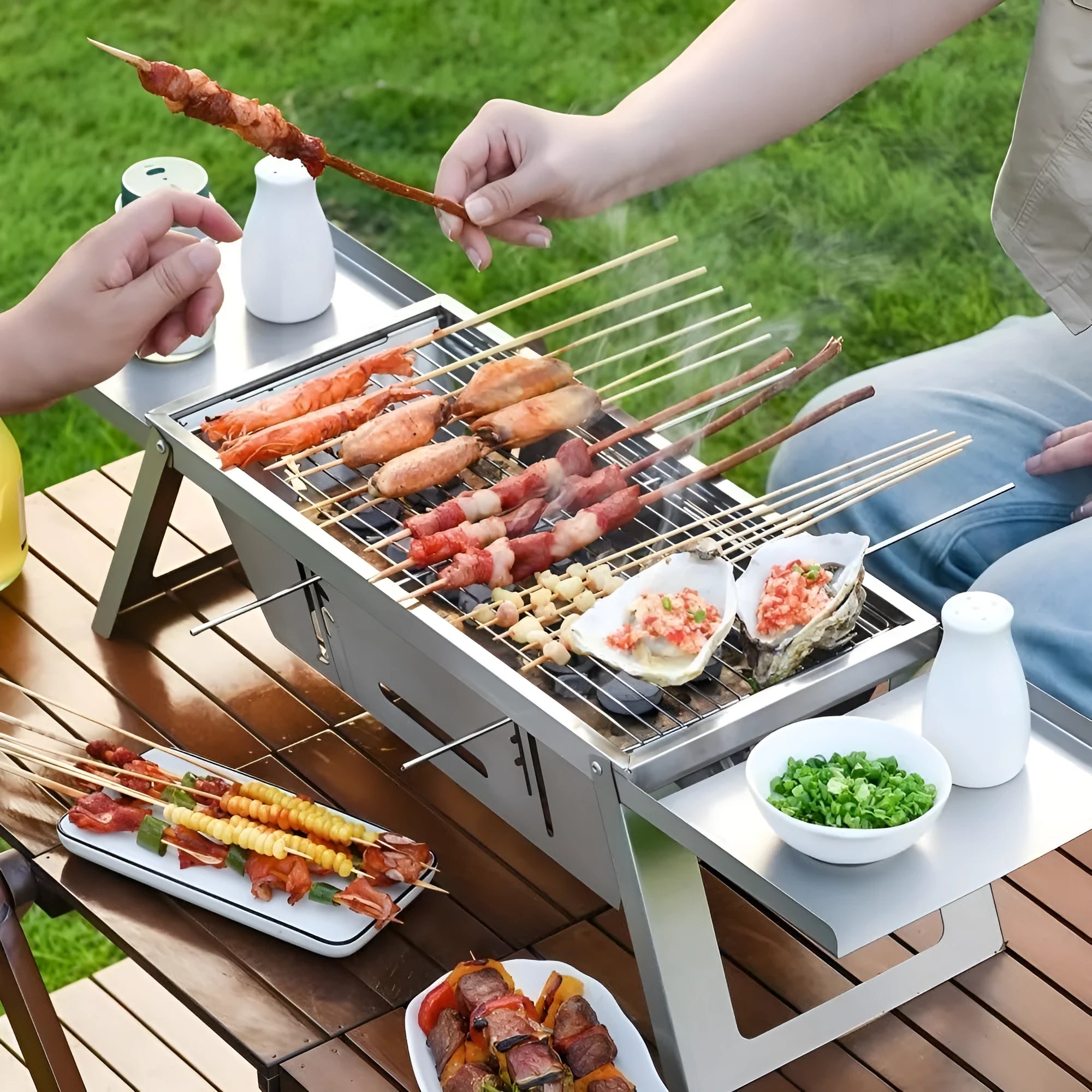 Small foldable portable charcoal grill shown in an outdoor setting