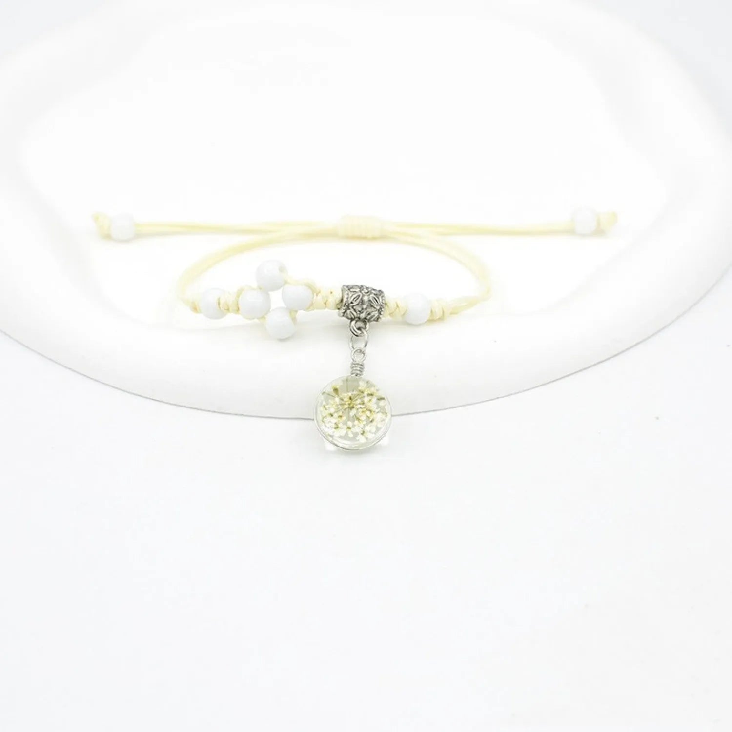 Close-up of a hand-woven glass bracelet with large 1.4 cm beads containing real dried flowers in multiple colour options.