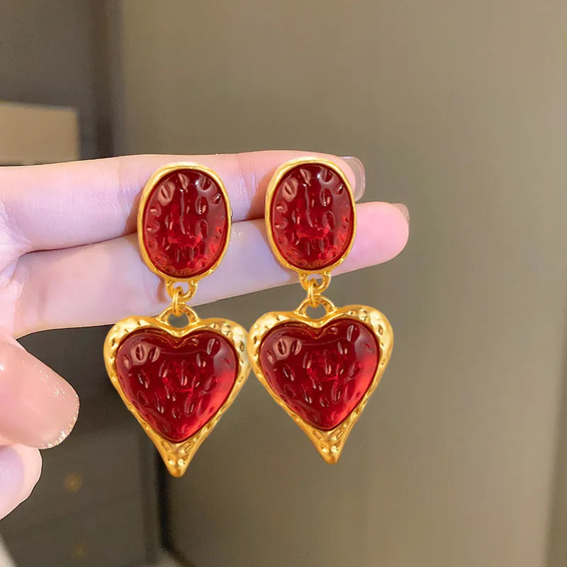 A pair of pleated oval love heart stud earrings in alloy, showing the silver needle post.