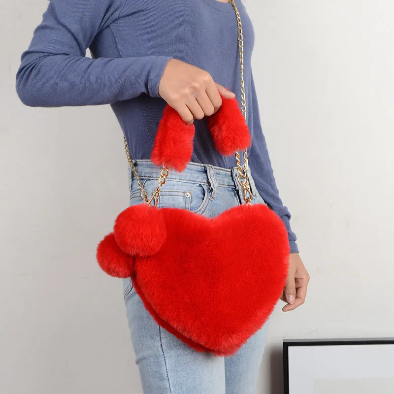 A soft plush heart-shaped women's handbag with a zipper and a detachable shoulder strap in a choice of 14 colours.