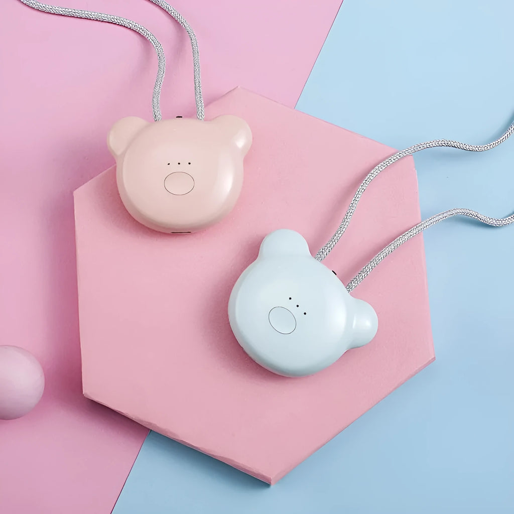 Small pink USB portable air purifier necklace on a table with charging cable.