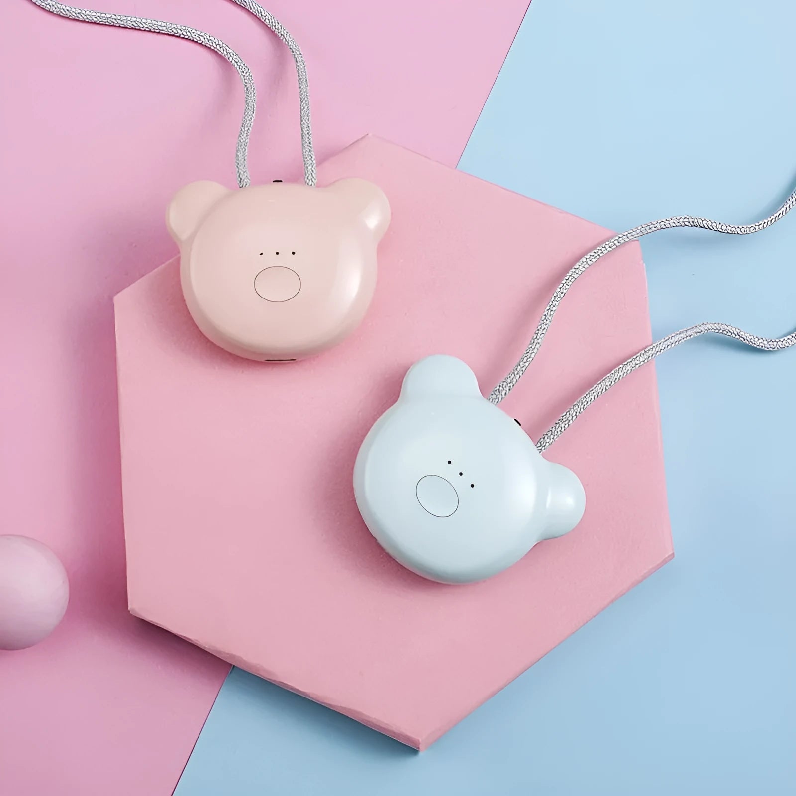 Small pink USB portable air purifier necklace on a table with charging cable.
