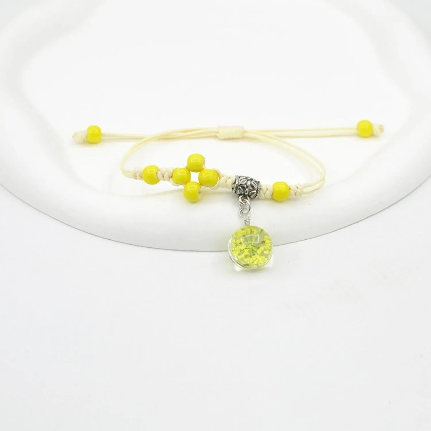 Close-up of a hand-woven glass bracelet with large 1.4 cm beads containing real dried flowers in multiple colour options.
