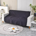 Reversible waterproof dog blanket laid flat on a sofa, showing two colour options.