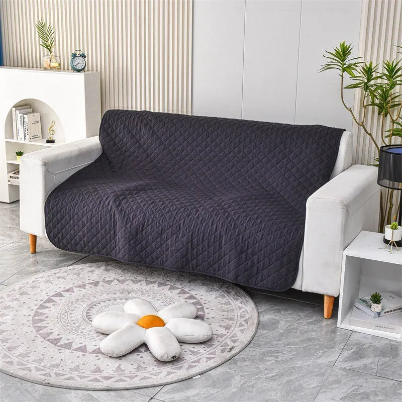 Reversible waterproof dog blanket laid flat on a sofa, showing two colour options.