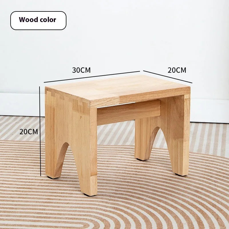 Rustic distressed wooden changing stool with bracket structure for shoe removal.