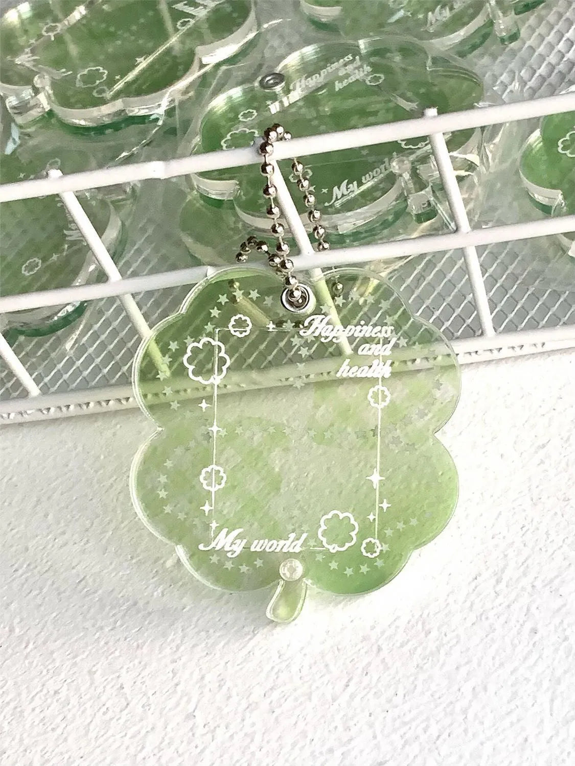 Acrylic four-leaf clover pendant charm for phone or keychain in blue or green colours.
