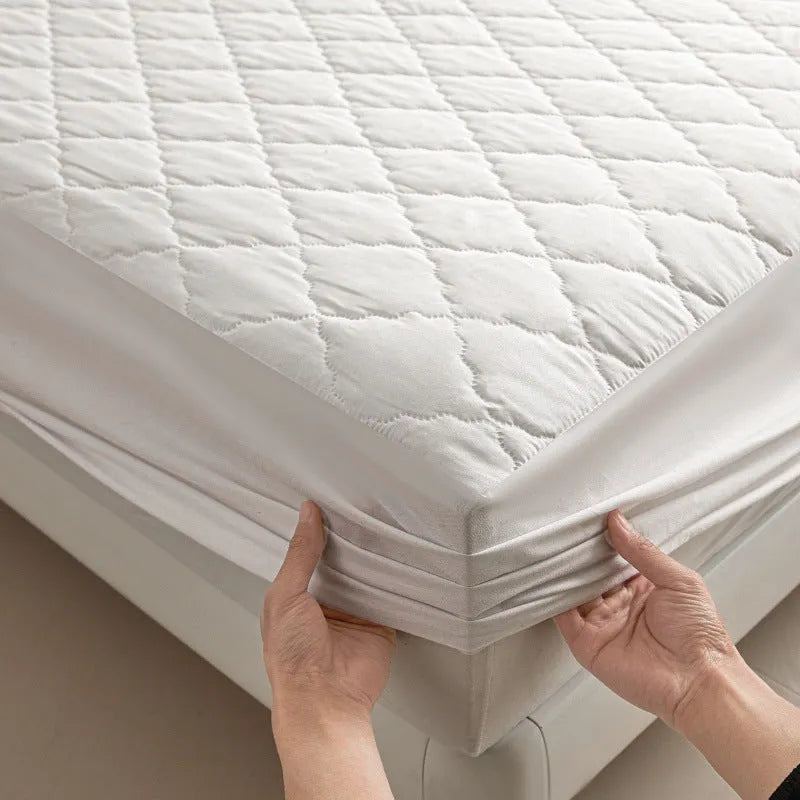 Diamond lattice quilted waterproof mattress protector in bamboo fibre shown on bed