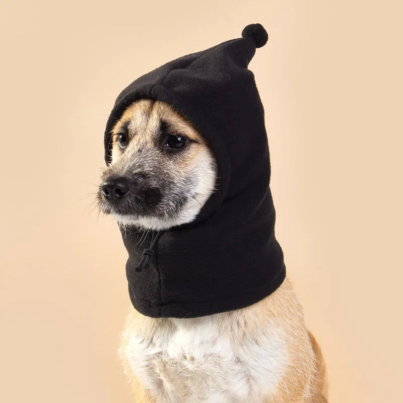 A dog or cat wearing a soft cloth bear headdress hat with upright rabbit ears, in leopard print colour.
