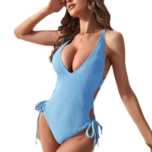 Backless one-piece women's swimsuit in polyester with tether detail, shown in black, light blue, fluorescent yellow, and light green.