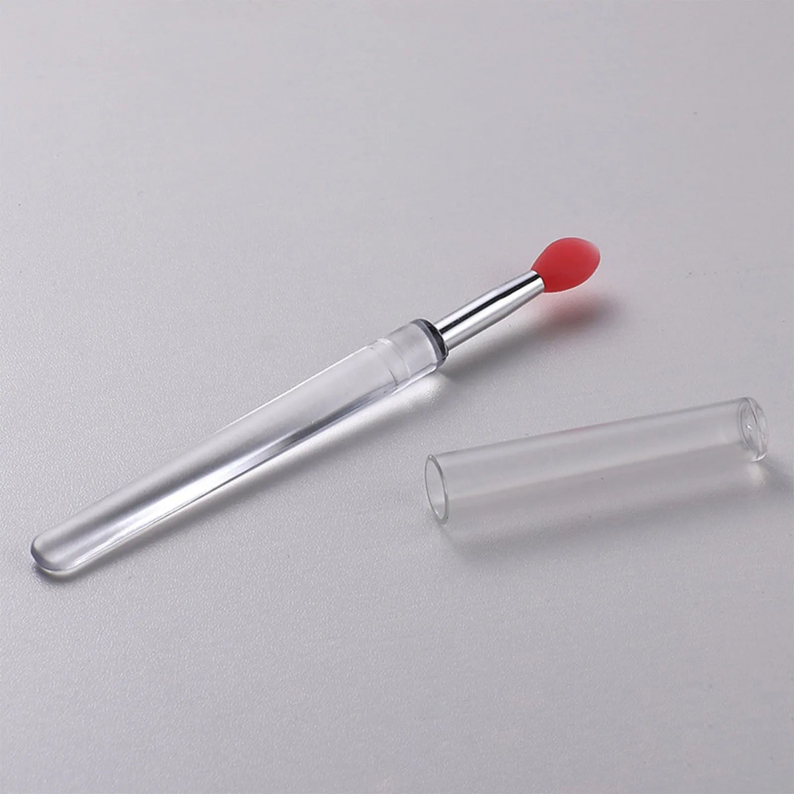 A reusable silicone lip brush with a handle and protective cap, shown in one of eight available colours.