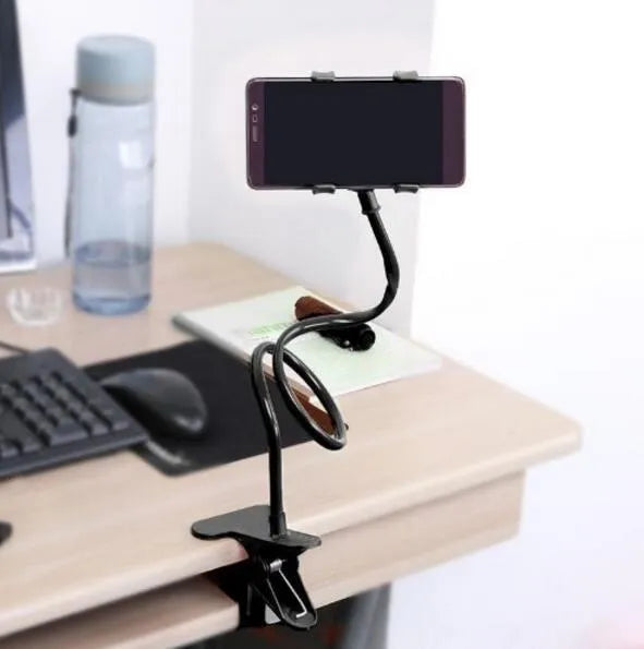 Black flexible arm phone holder with V-clip mounted on bed headboard holding smartphone