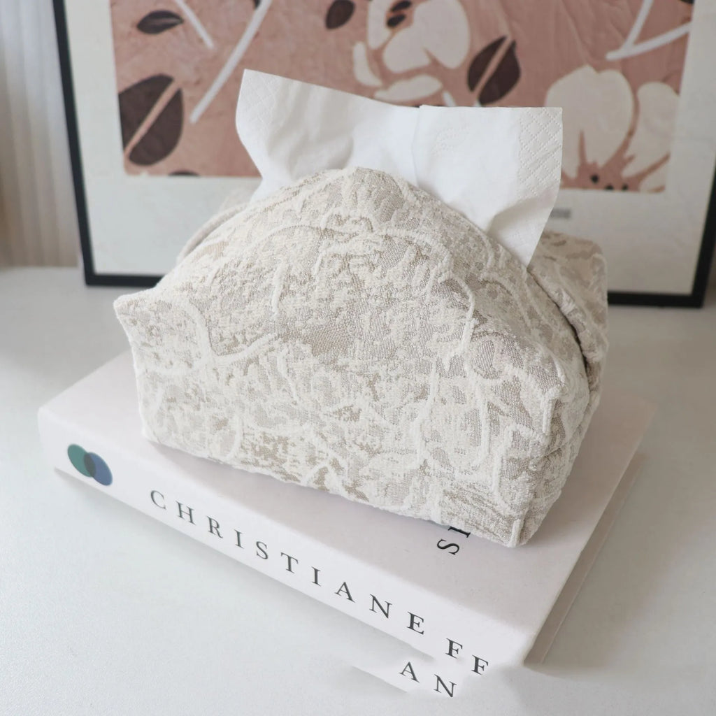 Handmade beige rose patterned cotton fabric tissue box cover on a wooden table.
