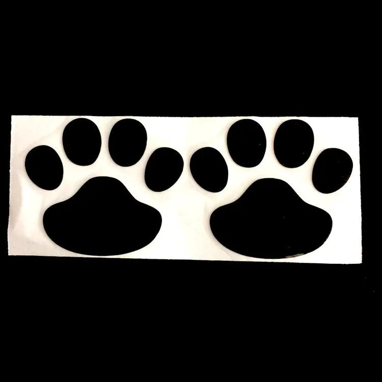 Pair of hand-shaped brush dog footprint PVC car stickers in red, shown against a car bumper.