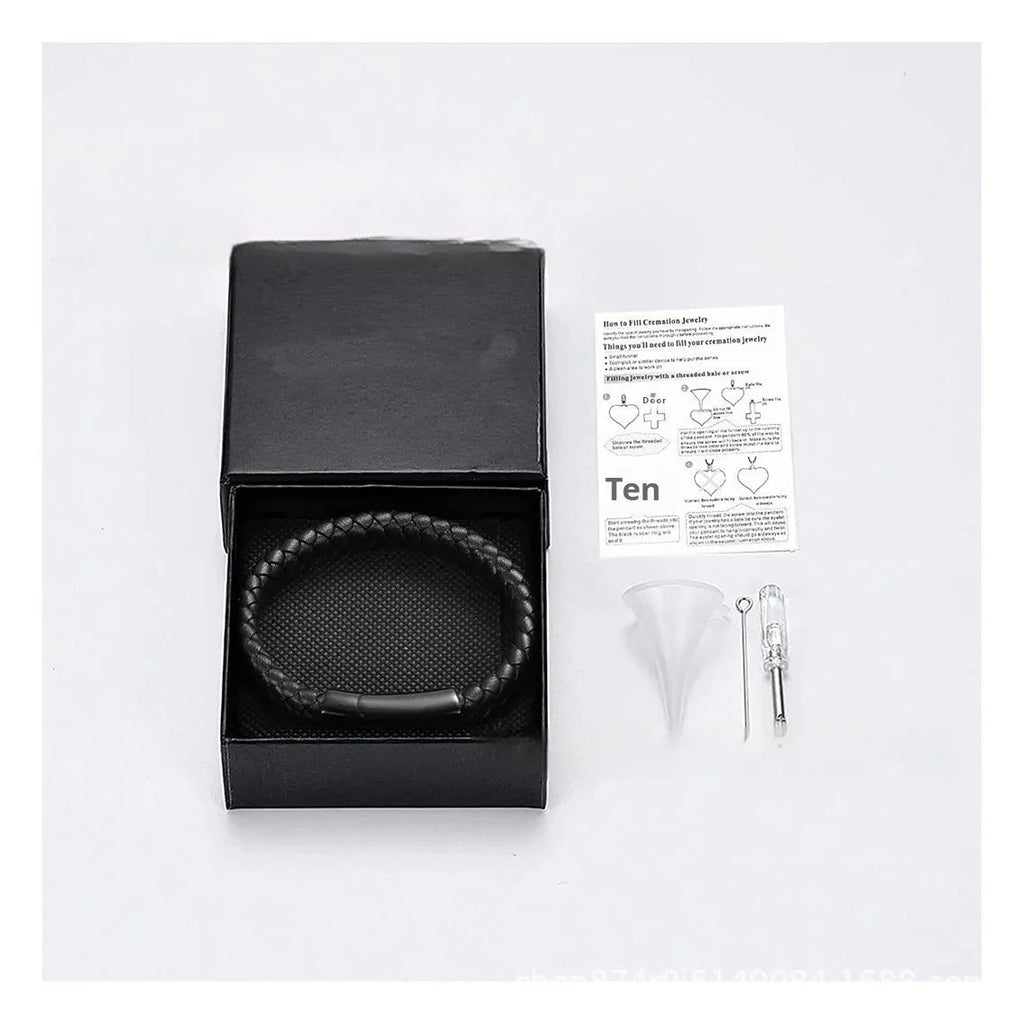 Black stainless steel memorial bracelet with a woven leather compartment for ashes and an engraved plate.