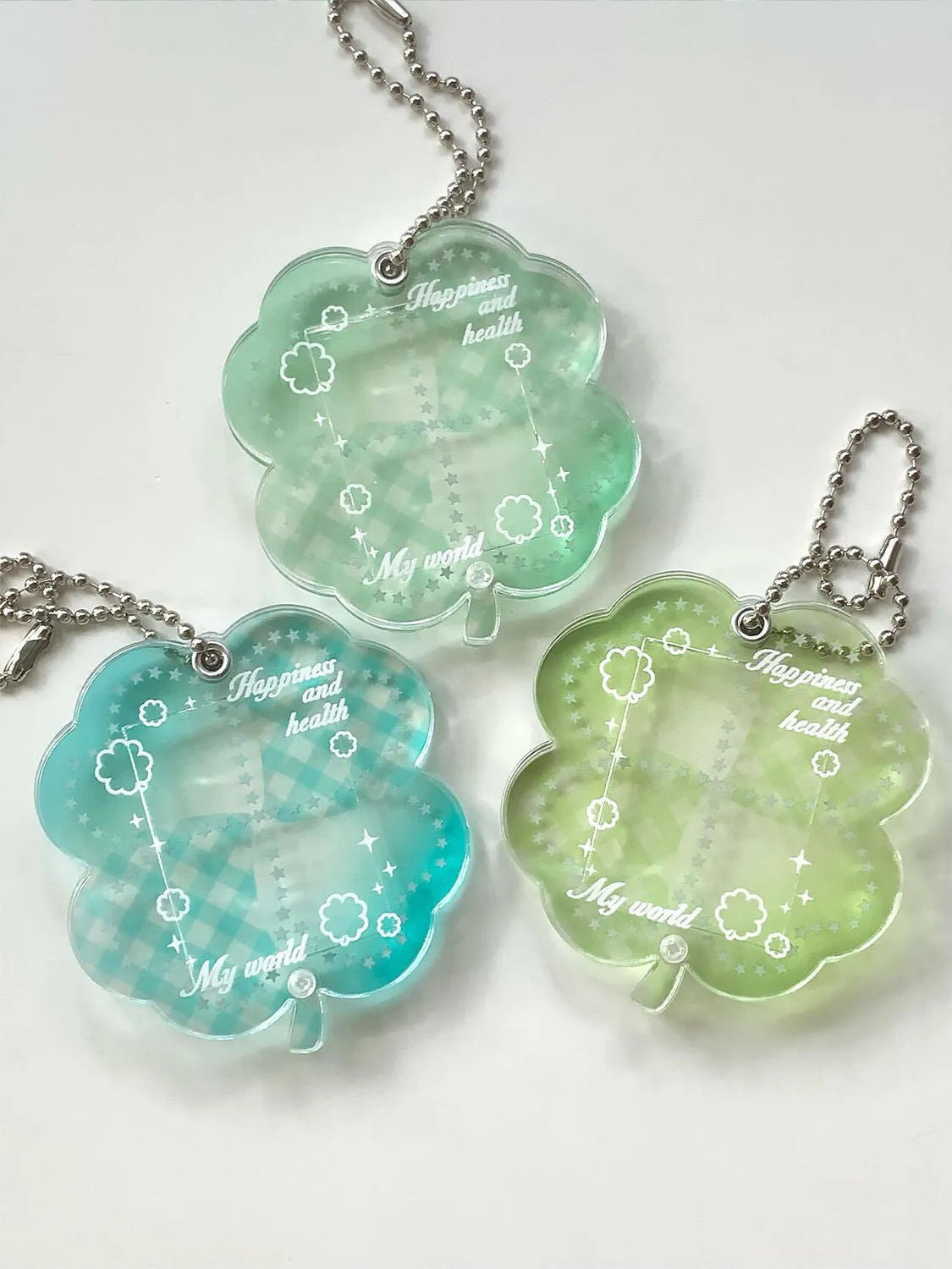 Acrylic four-leaf clover pendant charm for phone or keychain in blue or green colours.