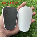 Pair of extra small black and white plastic football shin guards measuring 8x5cm for youth players