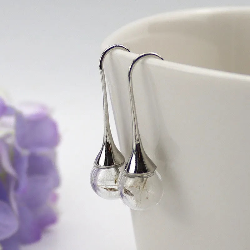 Transparent glass ball earrings with dandelion seed design and French hooks in silver or bronze finishes
