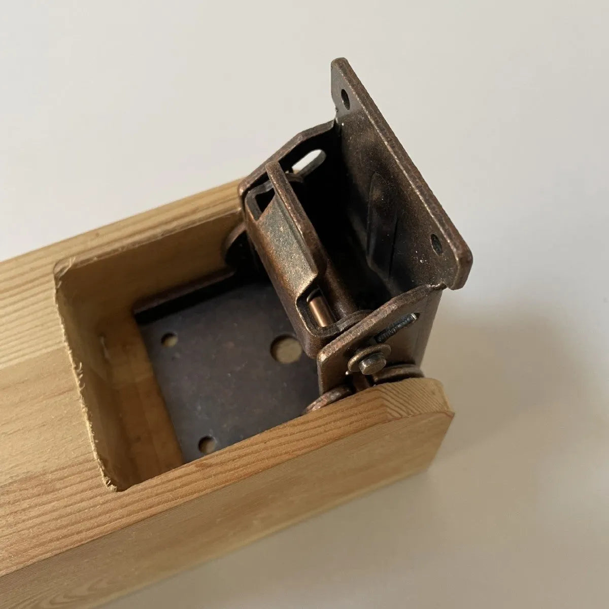 Close-up of a self-locking furniture folding hinge in an electroplated finish, set at a 90-degree angle.