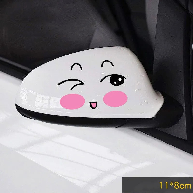 A pair of reflective cartoon eye car stickers on a vehicle rearview mirror.