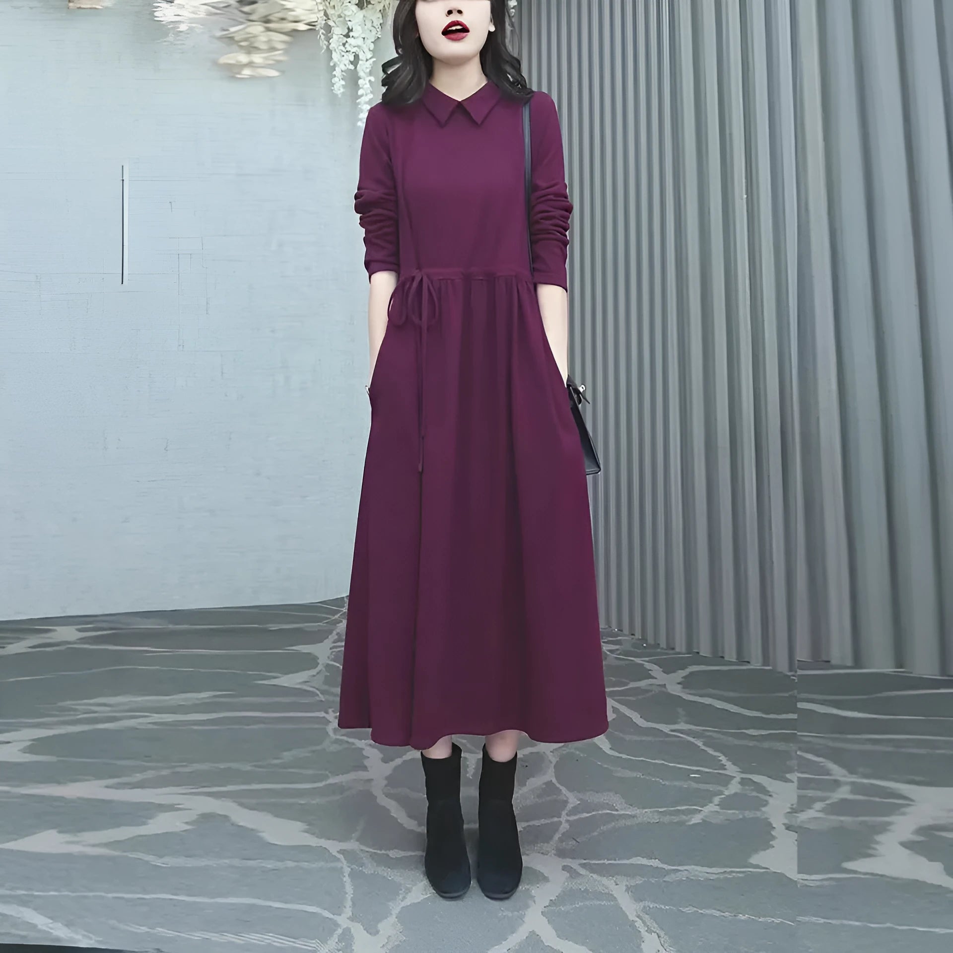 Purplish red plus size long sleeve dress for women with a long skirt, shown on a hanger.