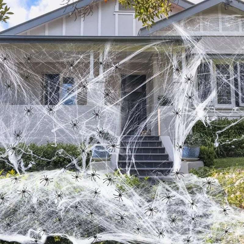 White cotton spider web Halloween decoration with multiple attached spiders draped over a surface.