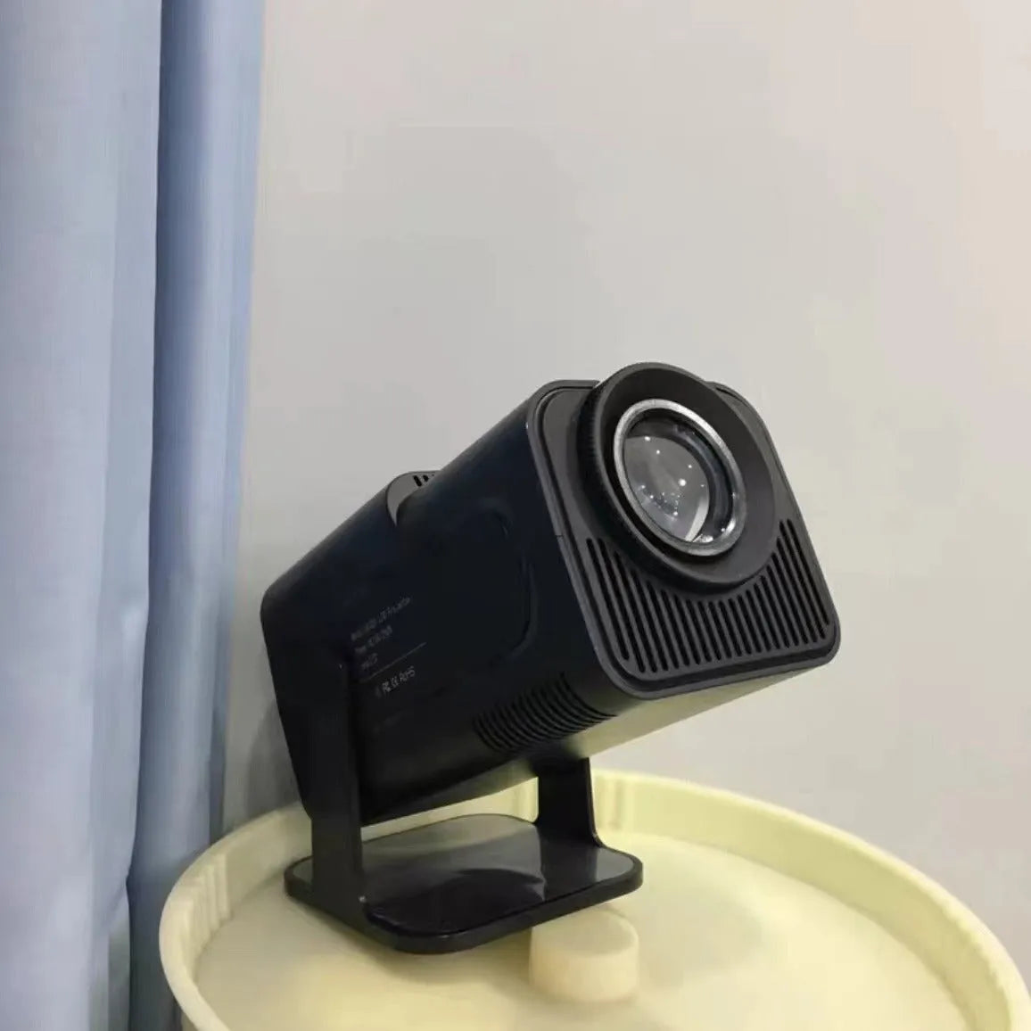 White portable home projector with handle showing 720p wireless gaming setup