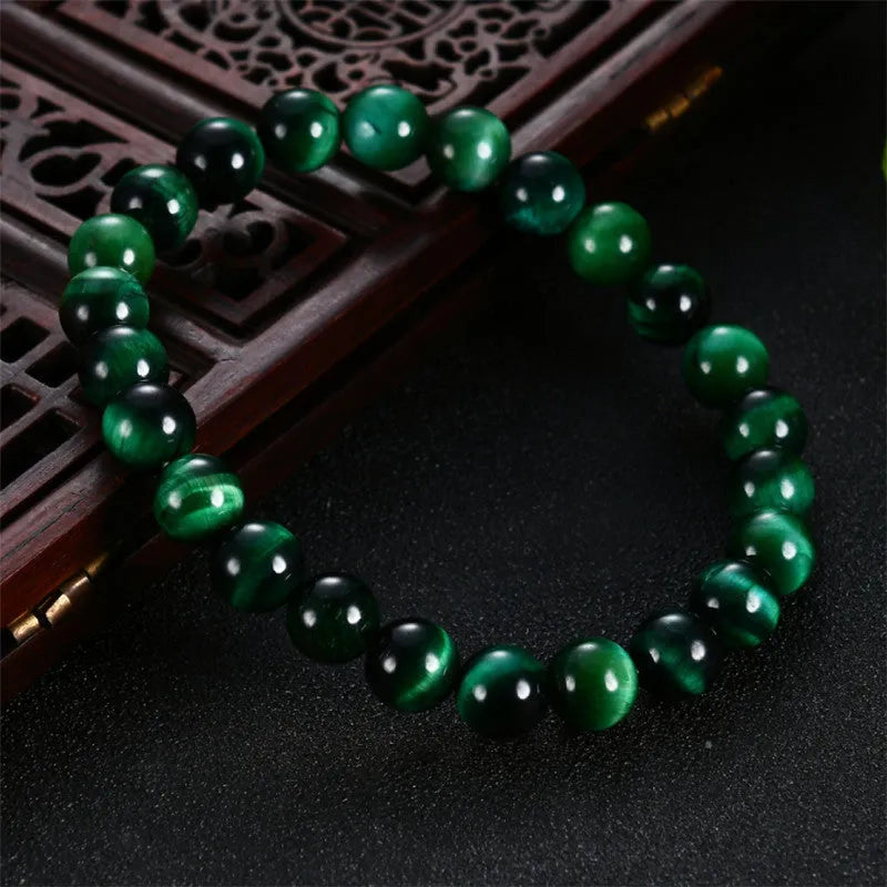 Green tiger eye stone bracelet with geometric beads on a wrist
