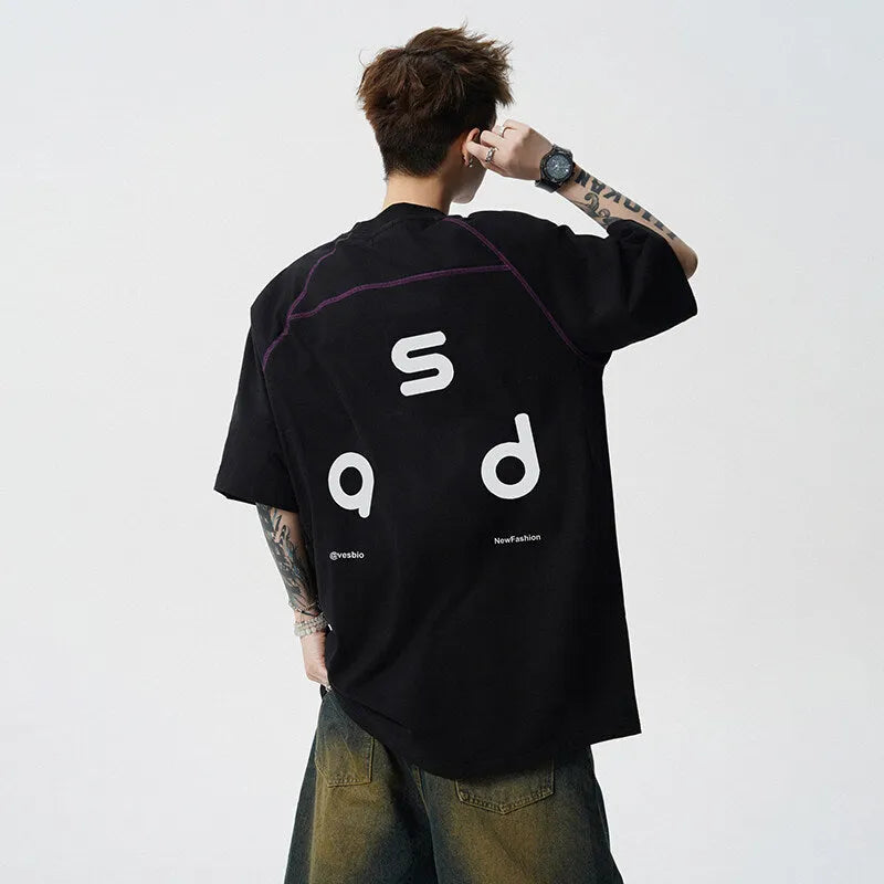 A loose-fitting black cotton short-sleeve T-shirt with a round neck on a hanger.