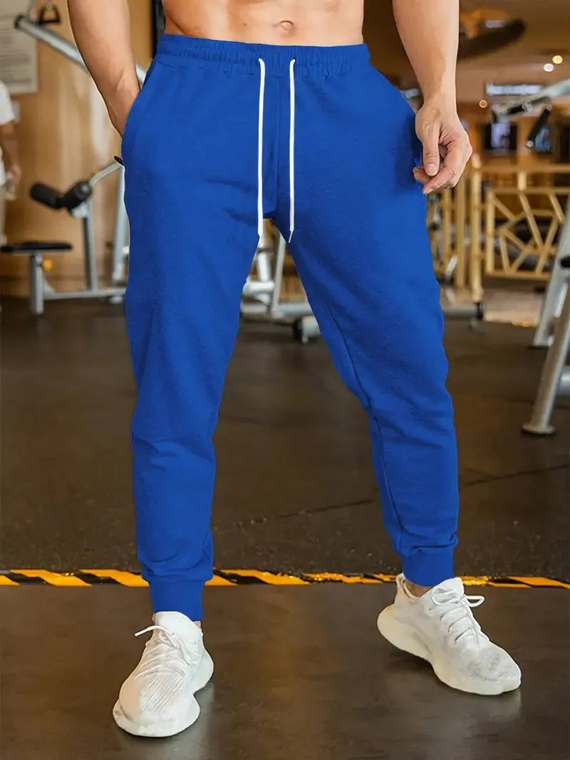 Men's loose-fit casual trousers with an elastic drawstring waist in a neutral colour.