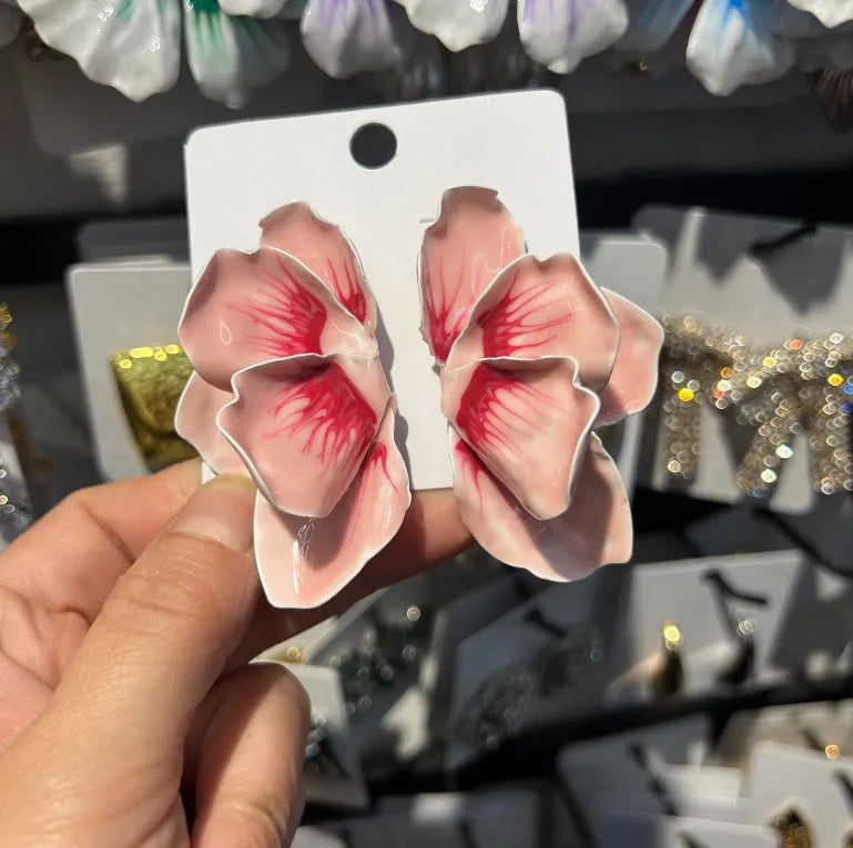 Close-up of women's alloy flower stud earrings with a blue oil-spot glaze and electroplated finish.