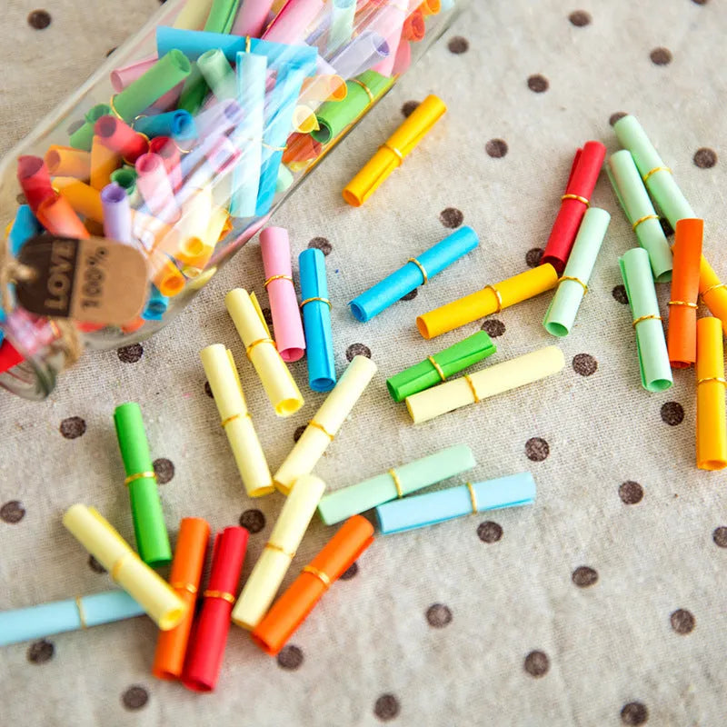 Assorted colour mini paper scrolls with punched holes for drift bottle notes and crafts.