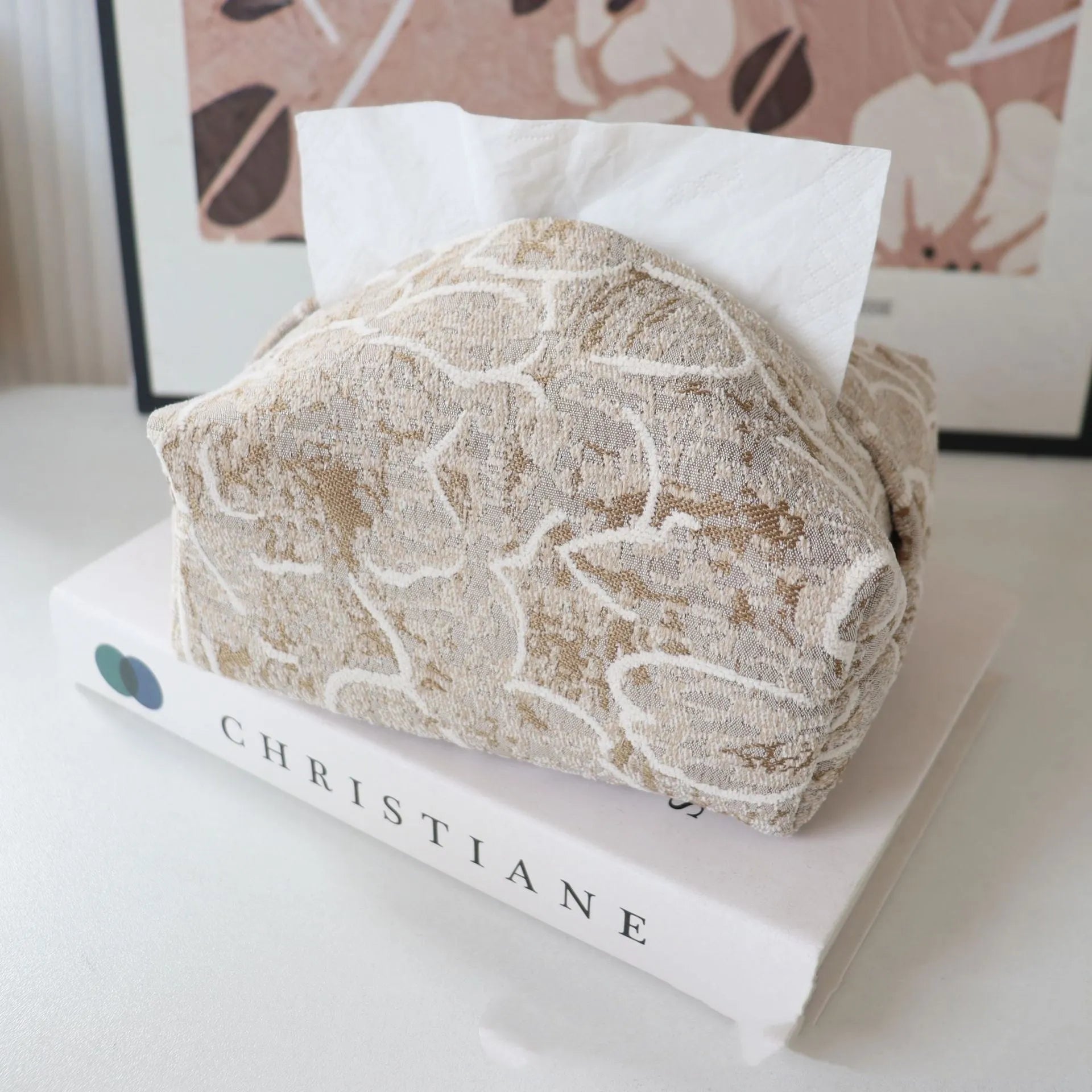 Handmade beige rose patterned cotton fabric tissue box cover on a wooden table.