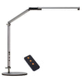 Folding aluminium desk lamp with a metal clip, shown in dazzling black, attached to a desk edge.