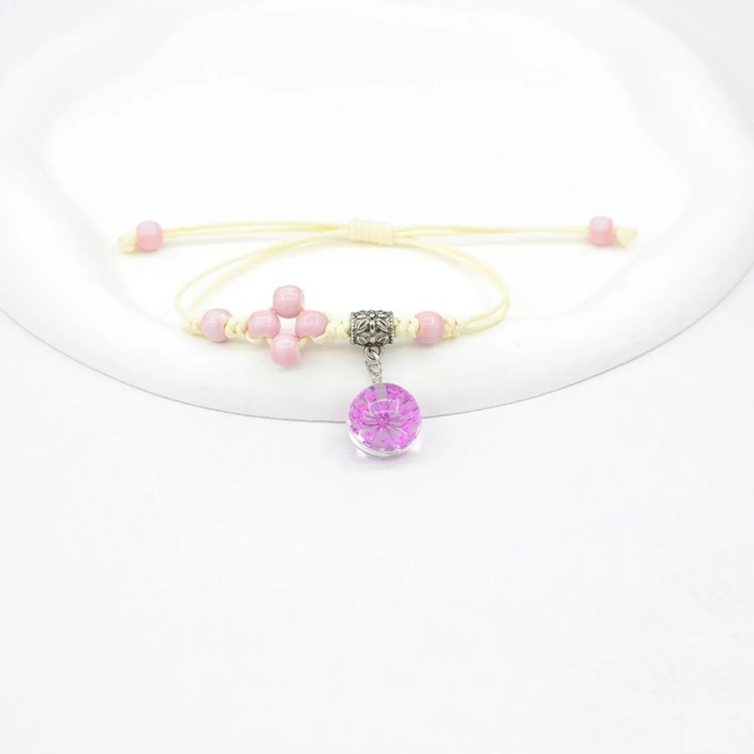 Close-up of a hand-woven glass bracelet with large 1.4 cm beads containing real dried flowers in multiple colour options.