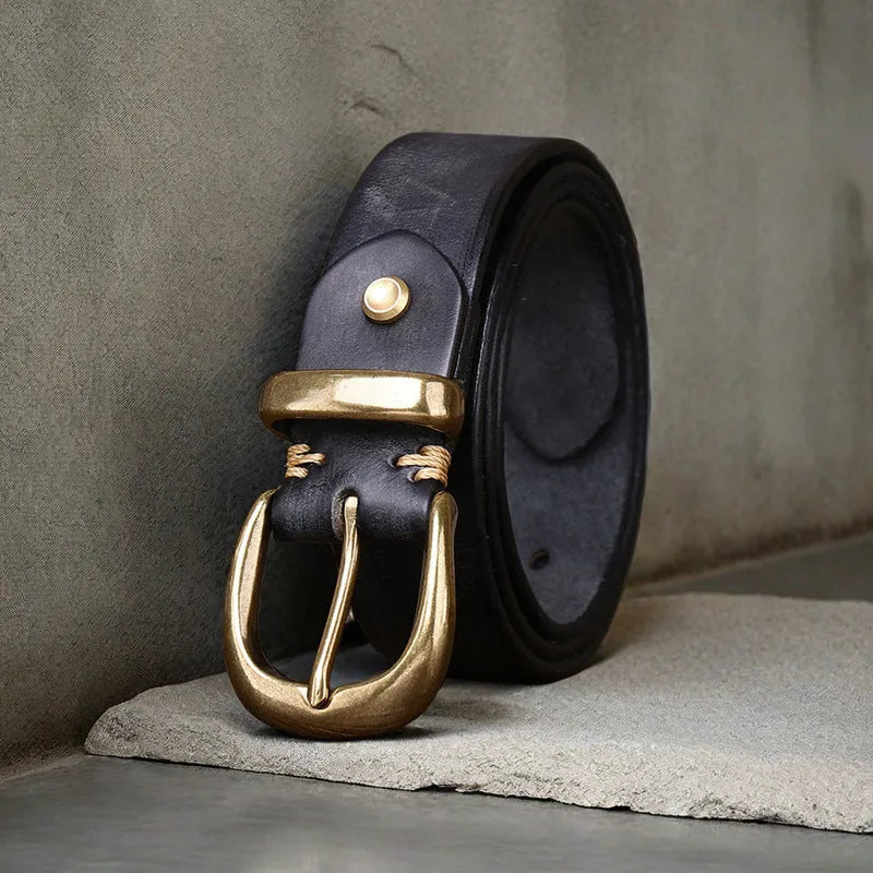 Men's black cattlehide leather belt with a copper pin buckle on a jeans background.