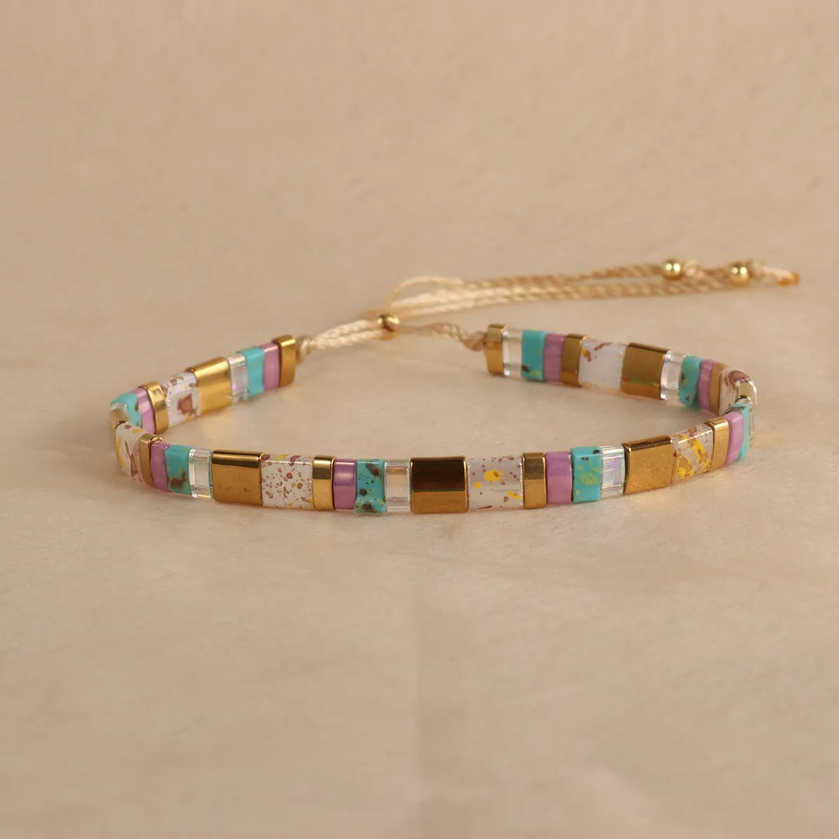 Geometric pull bead bracelet with round glass beads in multiple colour options.